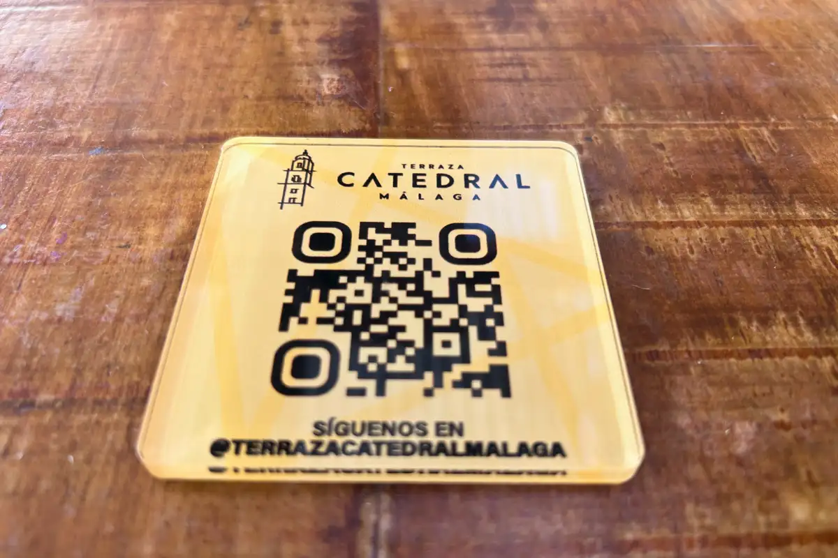 Terraza Catedral QR code social media sticker on a wooden table in Malaga