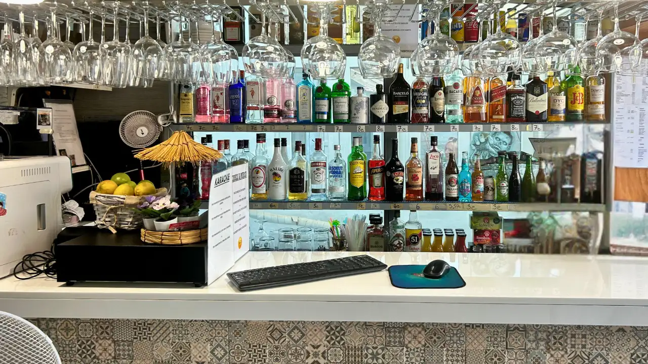 Cocktail bar counter with backlit spirit bottles and coffee machine at Terraza La Merced in Malaga