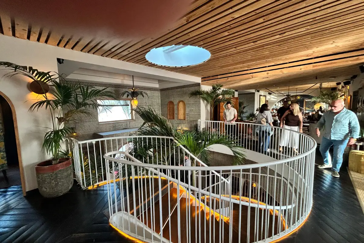 Curved interior staircase under a skylight with plants at Trocadero de Las Botes in Malaga