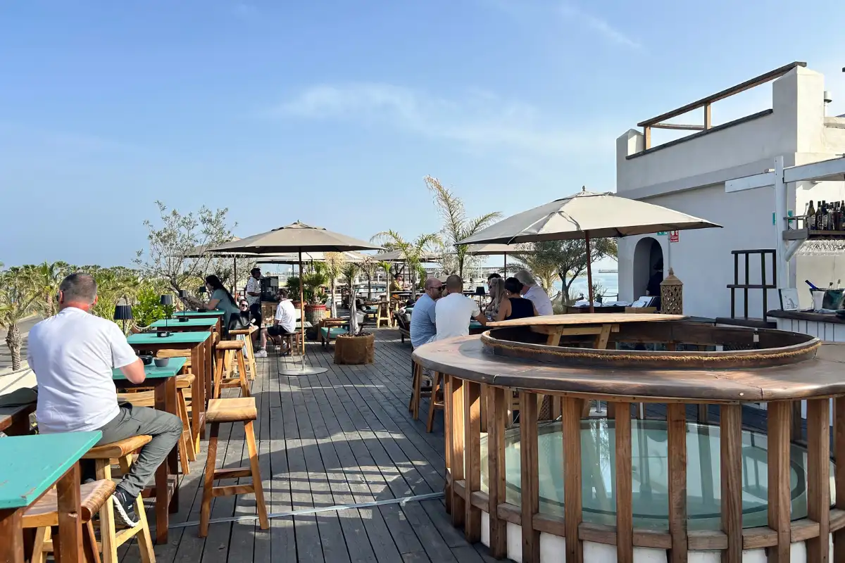 Guests dining at the rooftop terrace bar under parasols at Trocadero de Las Botes in Malaga