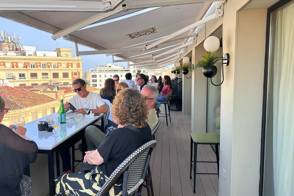 Wood-panelled cocktail bar with blue stools and bartenders at Vincci Larios Diez in Malaga