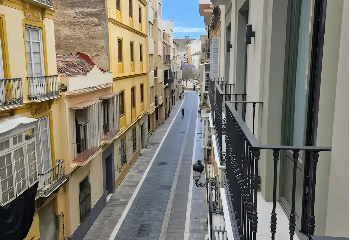 Narrow Malaga old town street seen from a Well and Come balcony