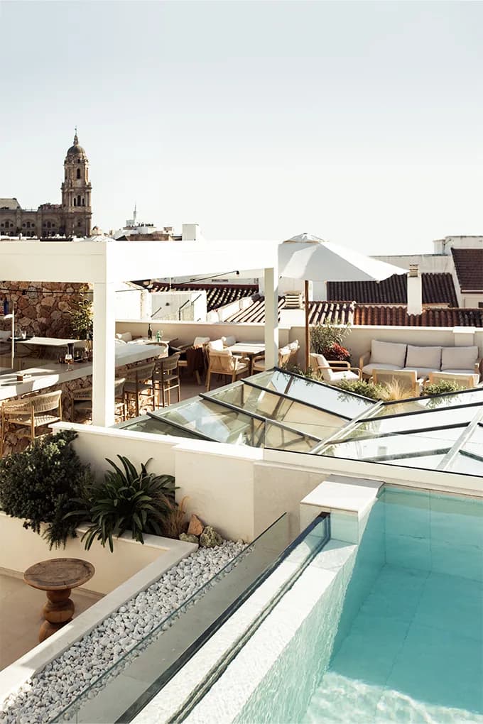 Rooftop terrace seating and pergola bar at Well and Come with Malaga cathedral tower behind