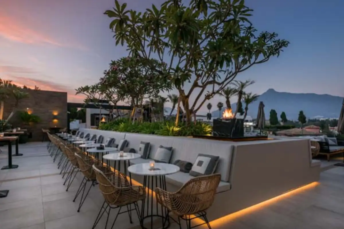 Dining terrace at sunset with mountain backdrop at Air by Breathe Marbella
