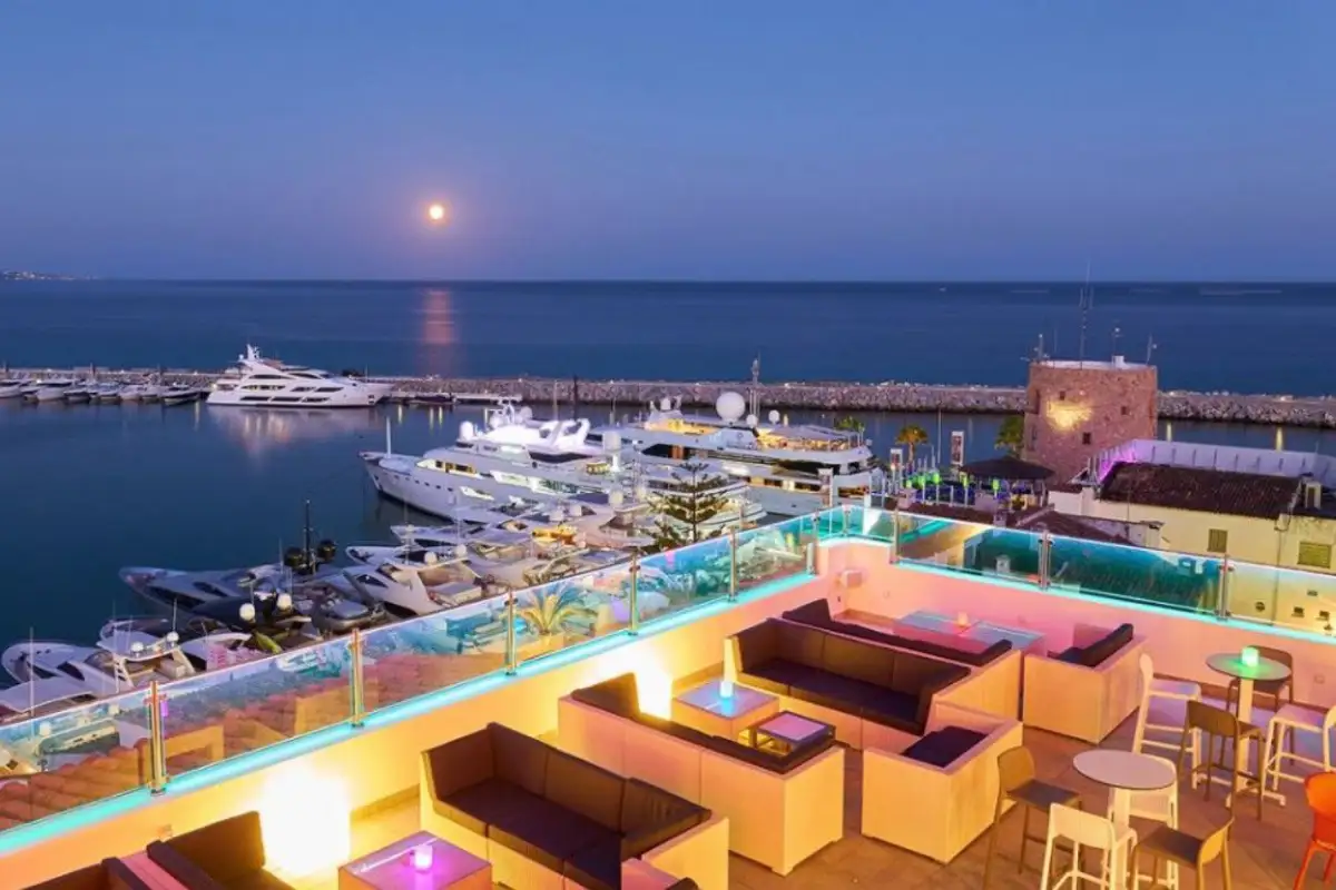 Lounge seating with moonlit marina view at Benabola Sky Lounge Marbella