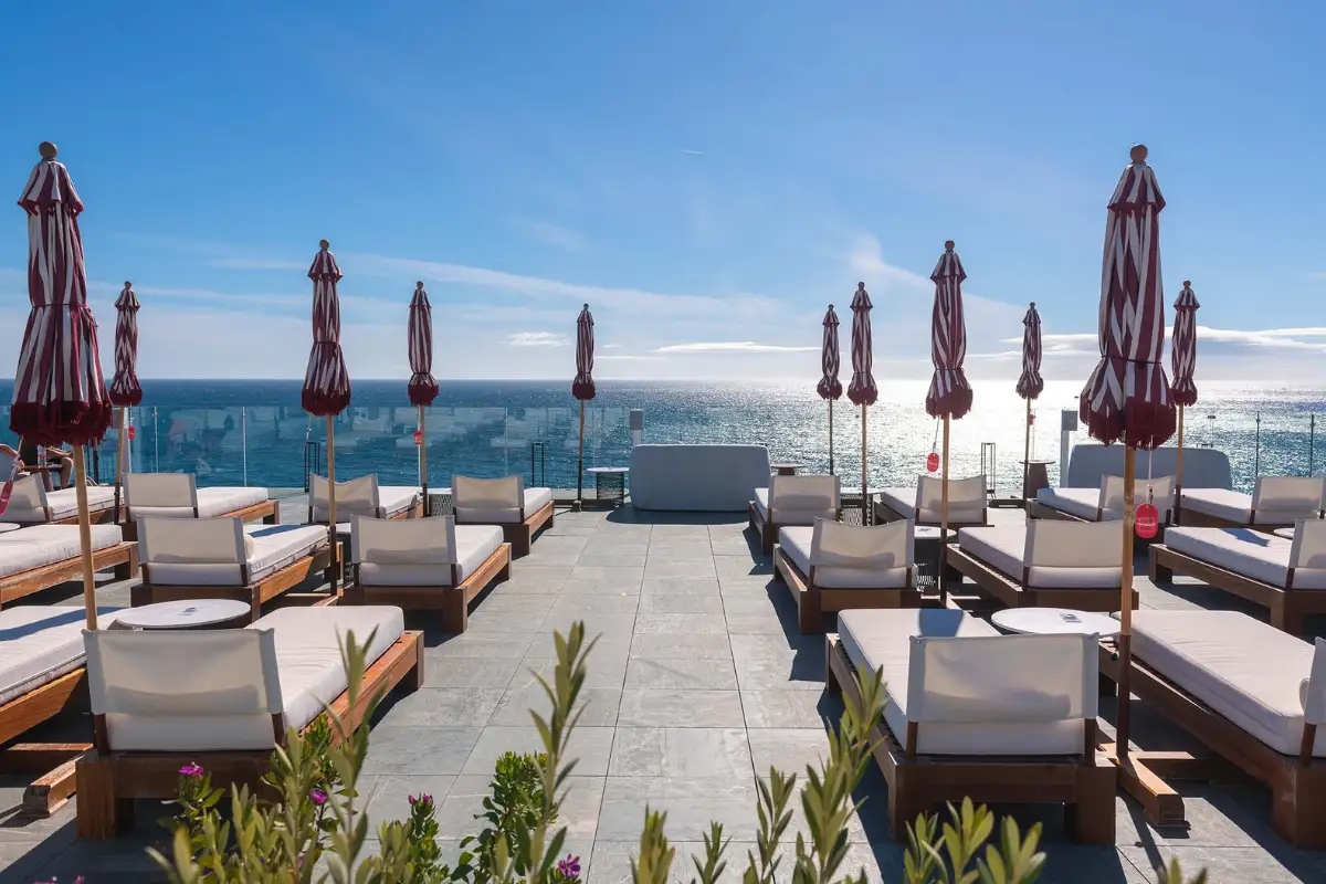 Rows of loungers and folded parasols on the sea-facing Edge at El Fuerte terrace, Marbella
