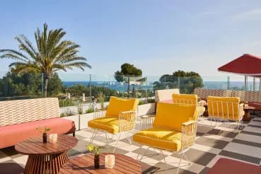 Yellow armchairs and palm trees on the sunset terrace at Escondido, Marbella