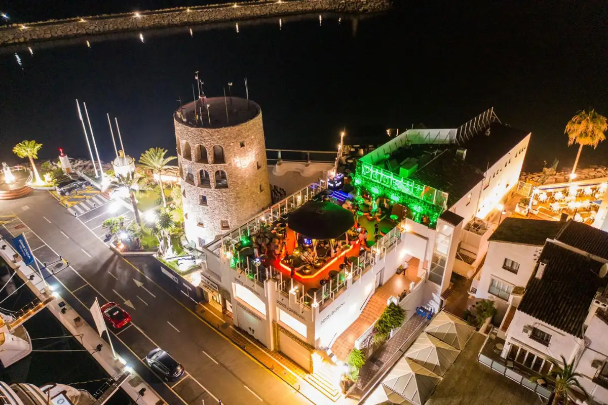 Aerial night view of the illuminated Pangea rooftop in Puerto Banus, Marbella