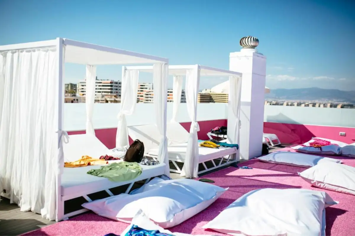 White canopy daybeds on the pink rooftop at Hotel Ritual in Torremolinos