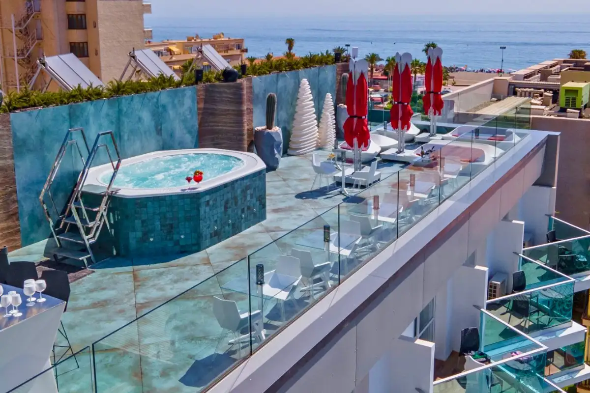 Rooftop jacuzzi with red parasols and sea views at Space Monkey Torremolinos