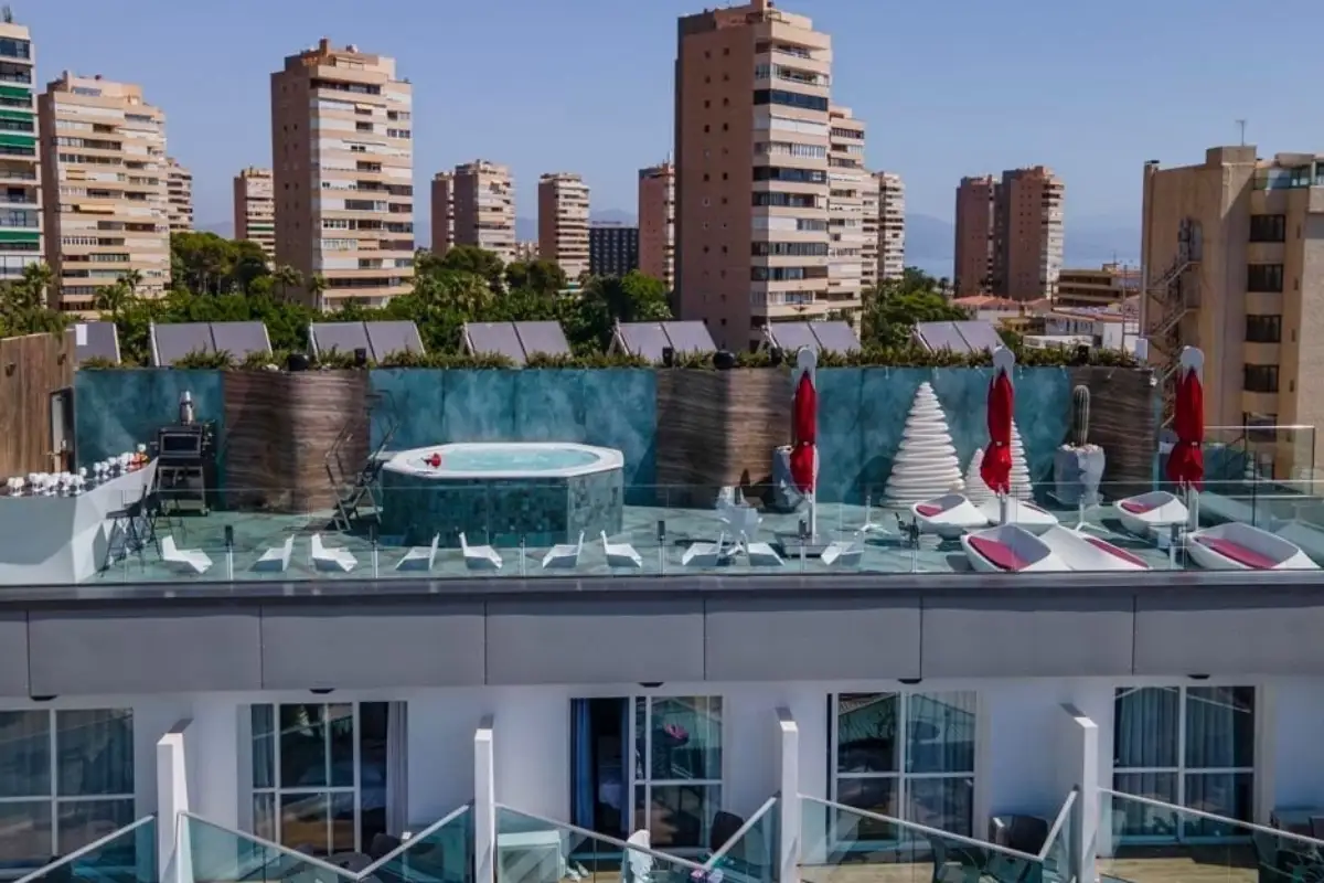Rooftop jacuzzi overlooking high-rise apartment blocks at Space Monkey Torremolinos