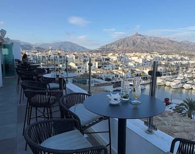 Terrace tables overlooking the marina and mountains at Sky Lounge, Benalmadena