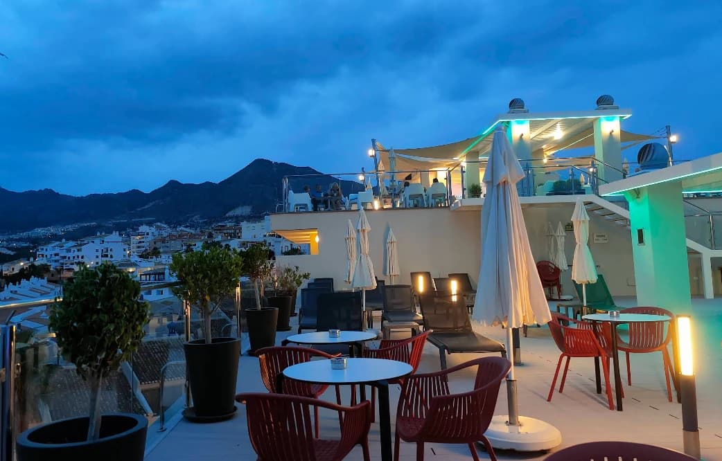 Illuminated terrace at night with town and mountain backdrop at Sky Lounge, Benalmadena