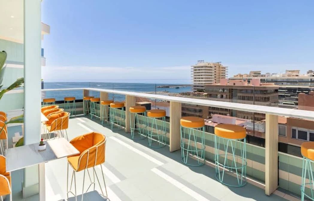 Terrace with orange bar stools overlooking the sea at 36-5 Rooftop, Hotel Angela Fuengirola