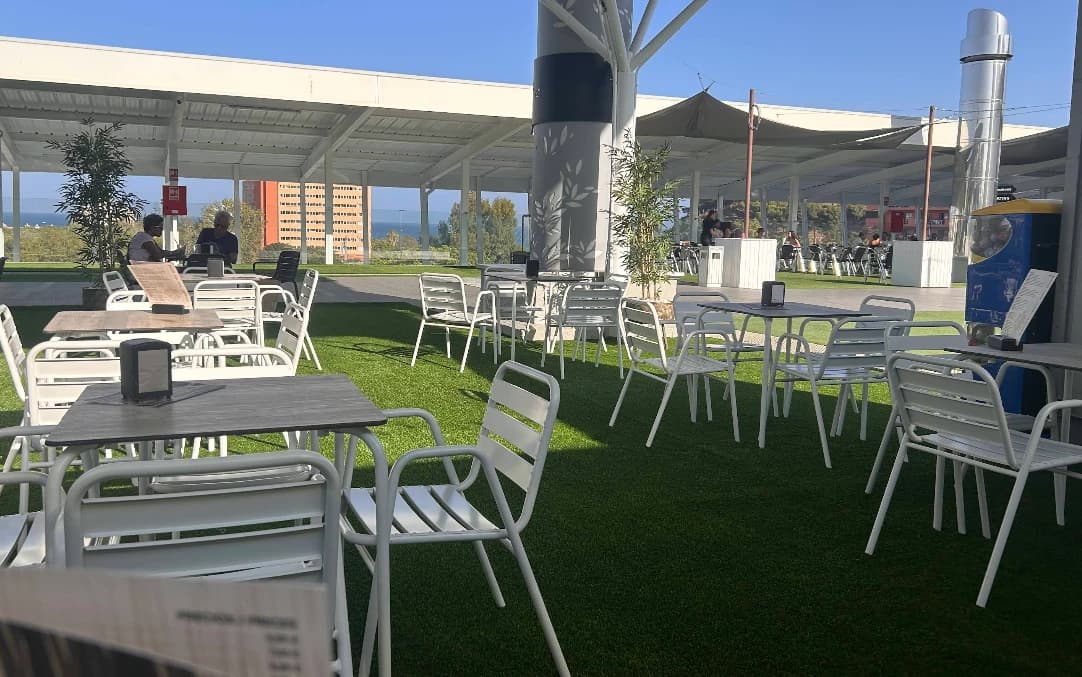 Grassy terrace with white tables and sea view at Terraza Chill Out, Miramar Fuengirola