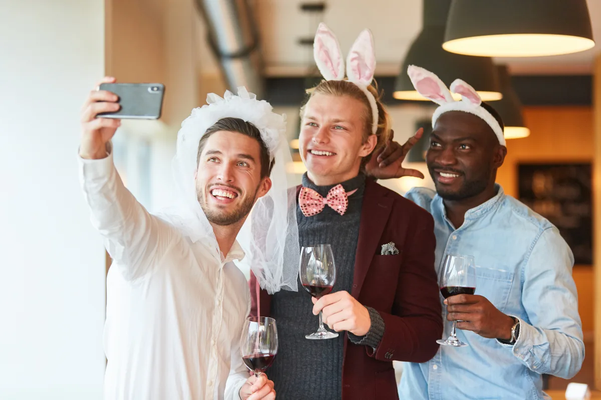 Men in bunny ears taking a selfie with wine glasses on a Malaga stag do