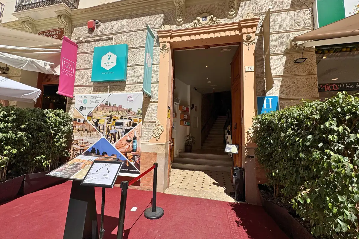 Red-carpeted street entrance with banners to La Terraza de Alcazaba in Malaga