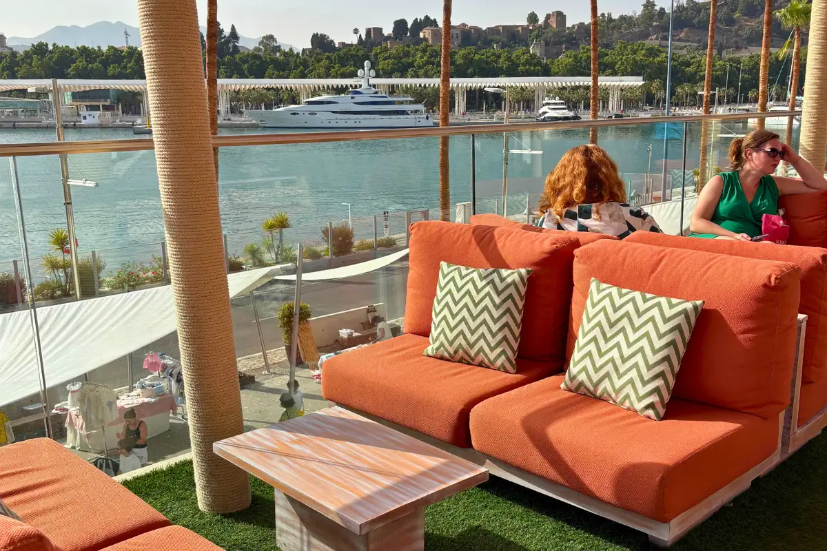 Orange lounge sofas with marina and yacht views at La Terraza Surfera in Malaga