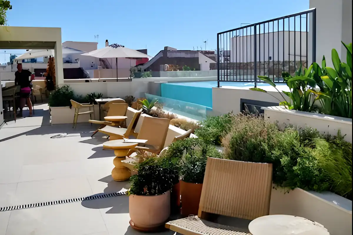 Sunny rooftop terrace with loungers and pool at Well and Come Malaga