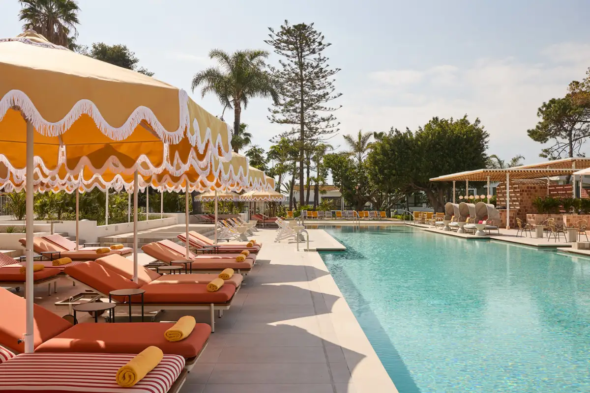 Striped loungers and yellow parasols beside the pool at Escondido, Los Monteros Marbella