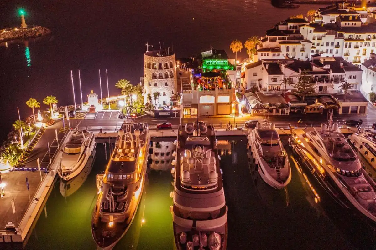 Yachts lit up in Puerto Banus marina at night seen from Pangea, Marbella
