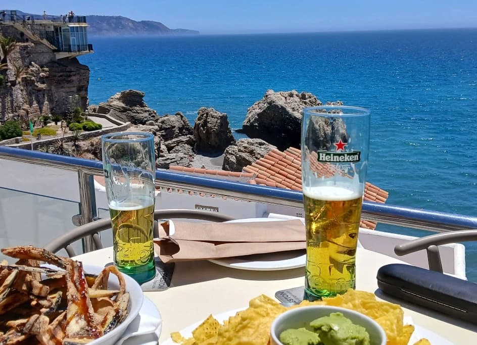 Two beers and snacks on a table above the sea at Cochran's Terrace, Nerja