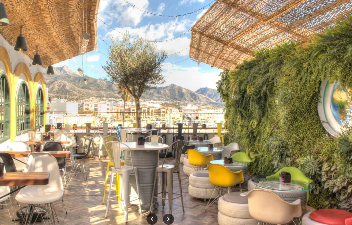 Sunny dining terrace with mountain views at Volks Bar in Nerja