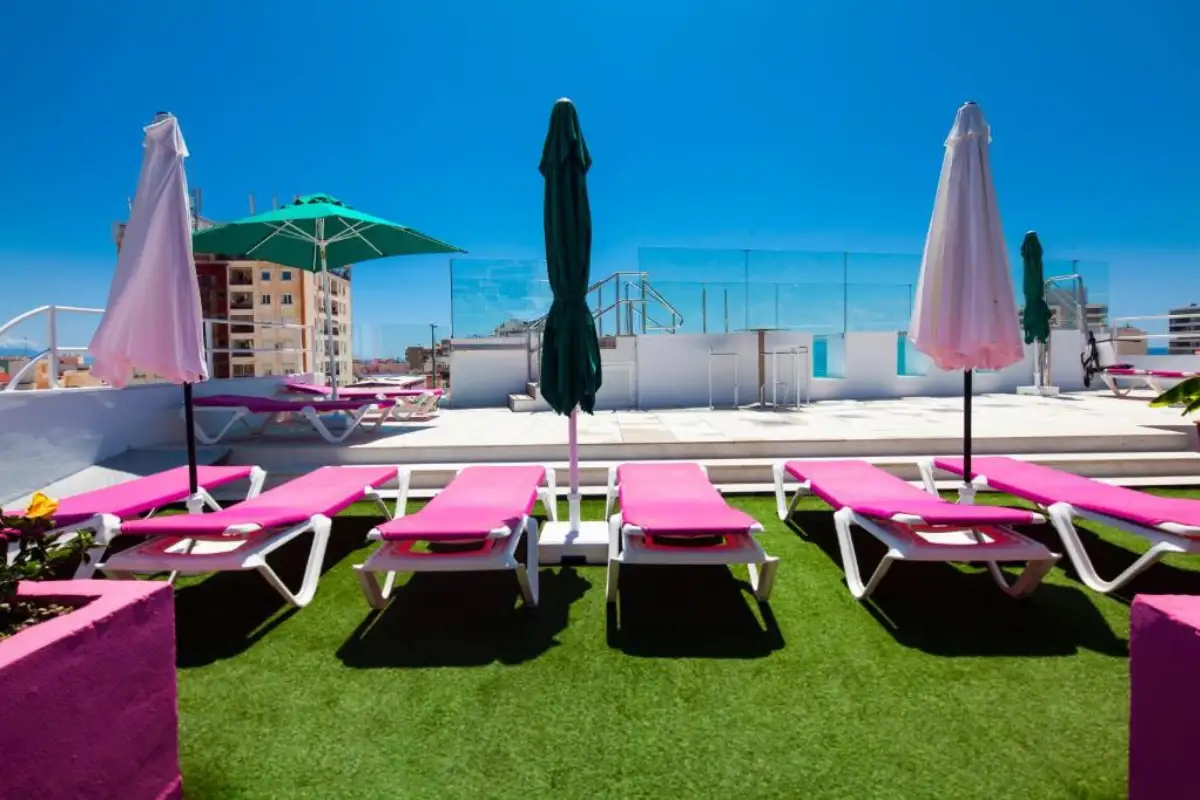 Pink sunbeds with parasols on the rooftop terrace at Gastrobar Sireno Torremolinos