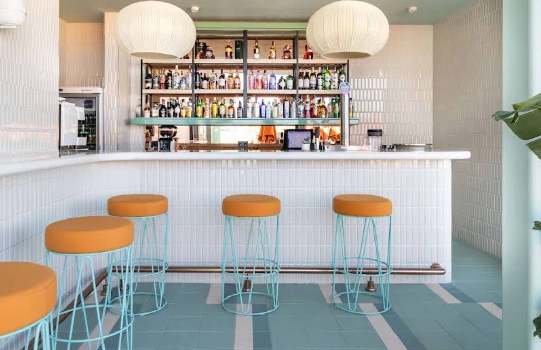 Pastel-toned cocktail bar with orange and teal bar stools at 36-5 Rooftop, Hotel Angela Fuengirola