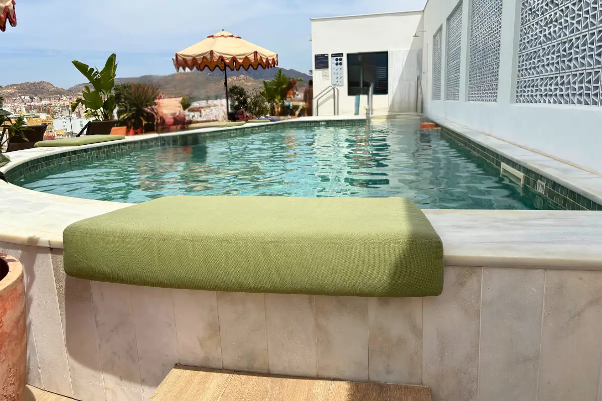 Rooftop pool with cushioned ledge and parasol at H10 Croma, Malaga
