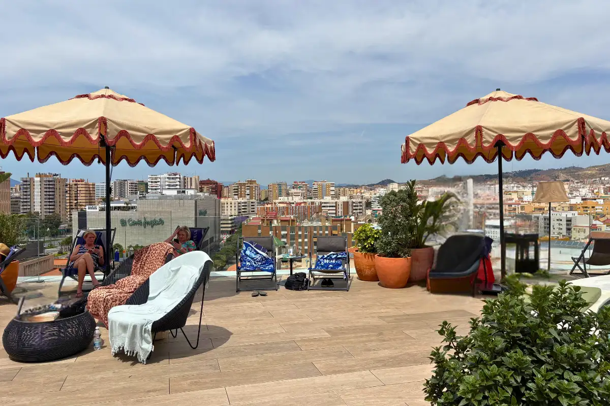 Sunloungers under parasols on the H10 Croma rooftop overlooking Malaga
