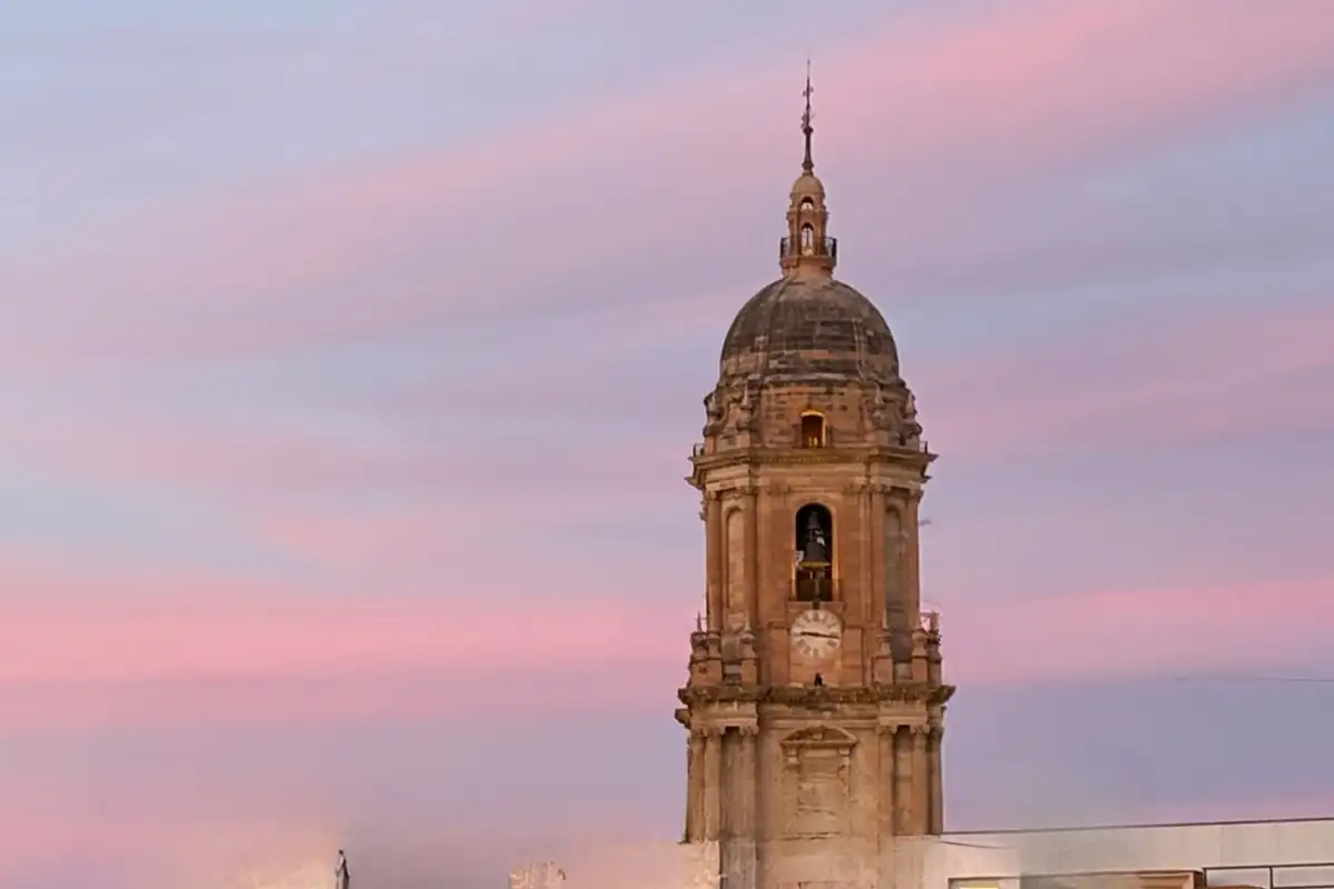 Malaga Cathedral dome against a pink sunset sky from La Terraza de San Juan