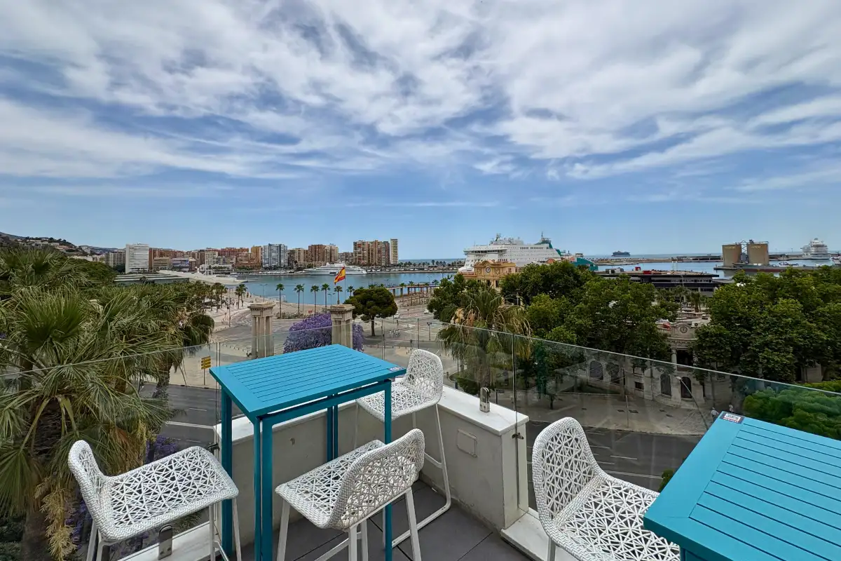 Blue terrace tables with a sweeping port view at La Terraza de Valeria in Malaga
