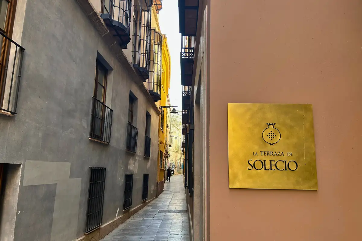 Entrance sign for La Terraza Solecio on a narrow old town alley in Malaga