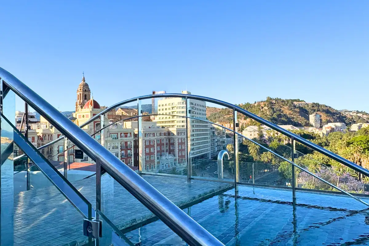 Glass-walled rooftop pool with cathedral view at Lolita Skyview in Malaga