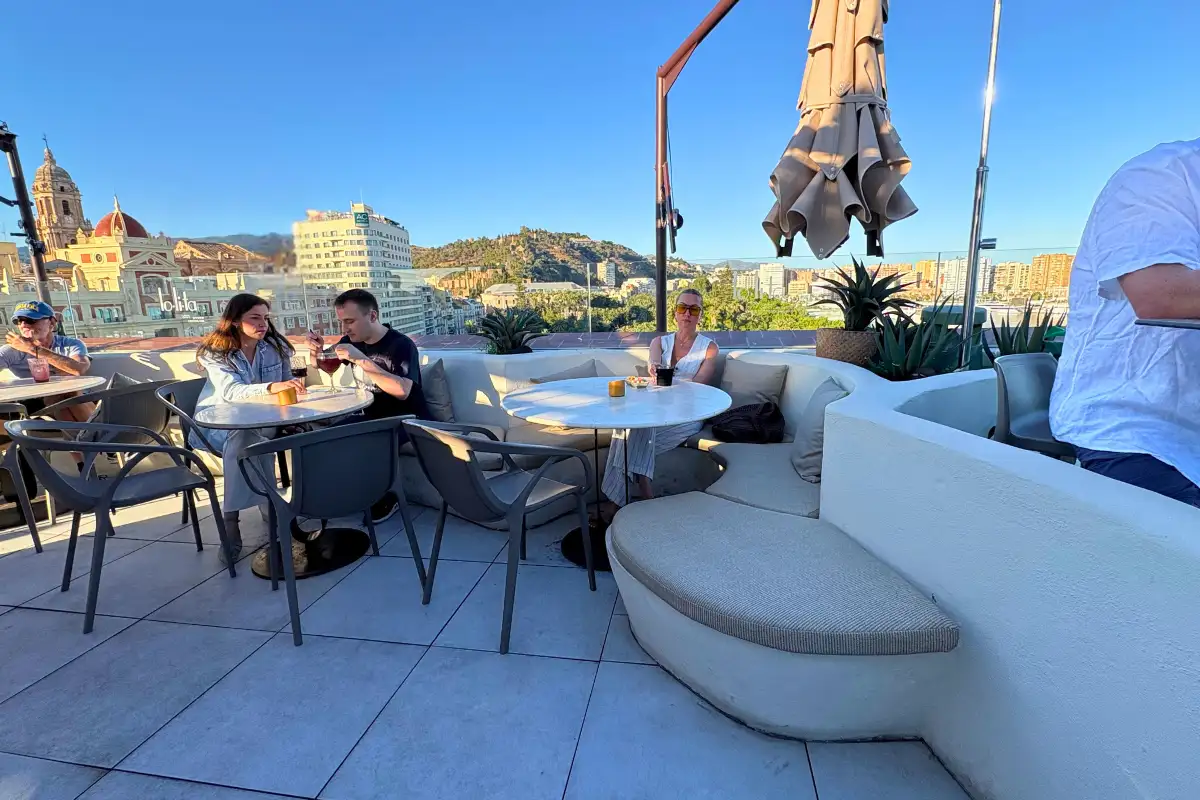 Terrace seating with guests and cathedral view at Lolita Skyview in Malaga