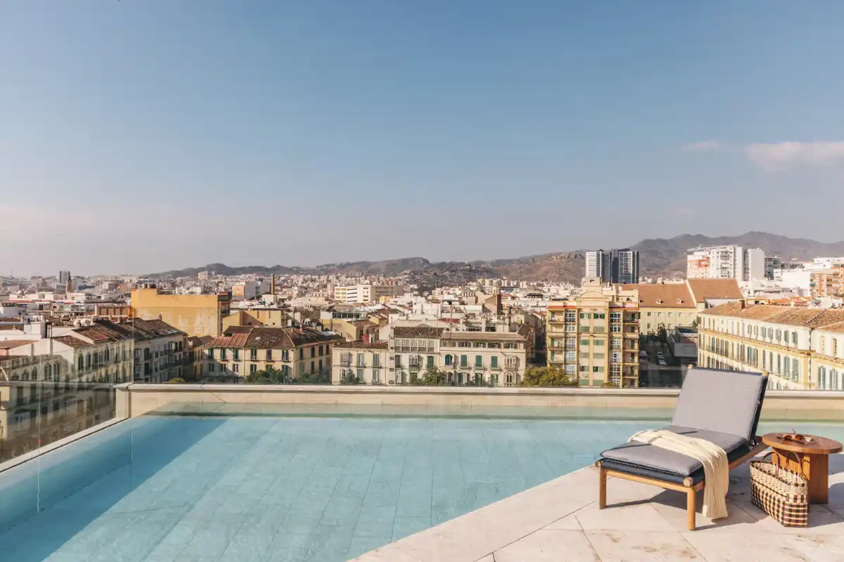 Rooftop infinity pool and lounger overlooking the Malaga city skyline at ME Malaga