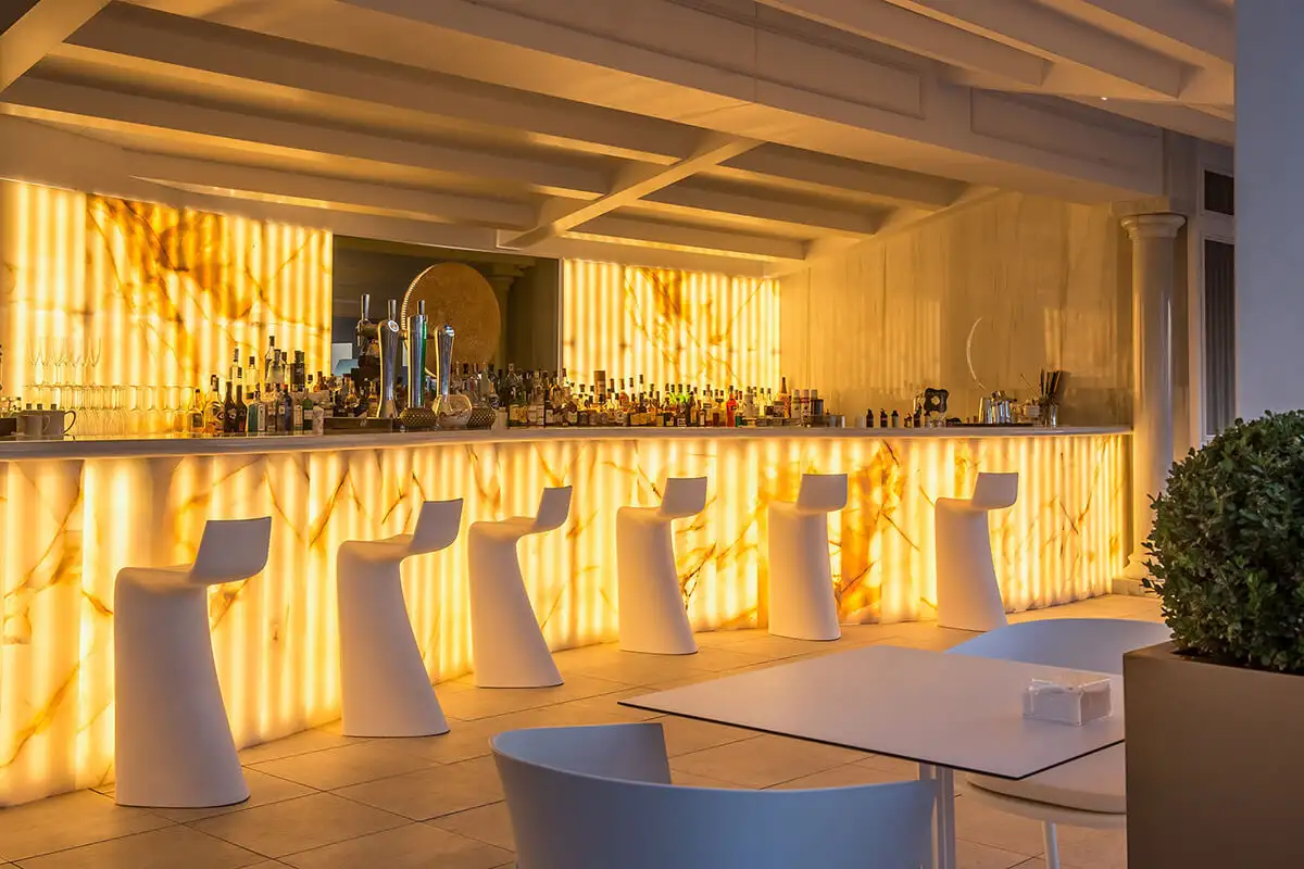 Backlit cocktail bar with white stools at Media Luna, Gran Hotel Miramar, Malaga
