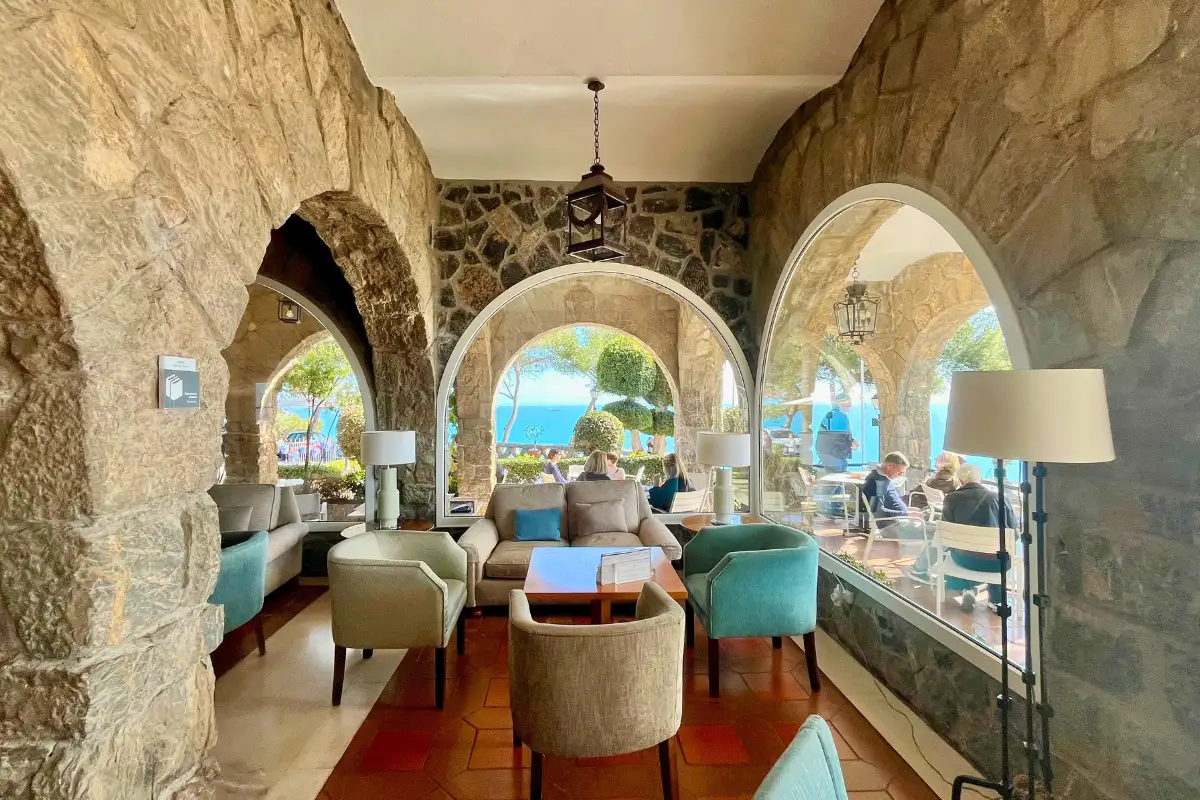 Stone-arched lounge with armchairs and sea views at Parador de Malaga Gibralfaro