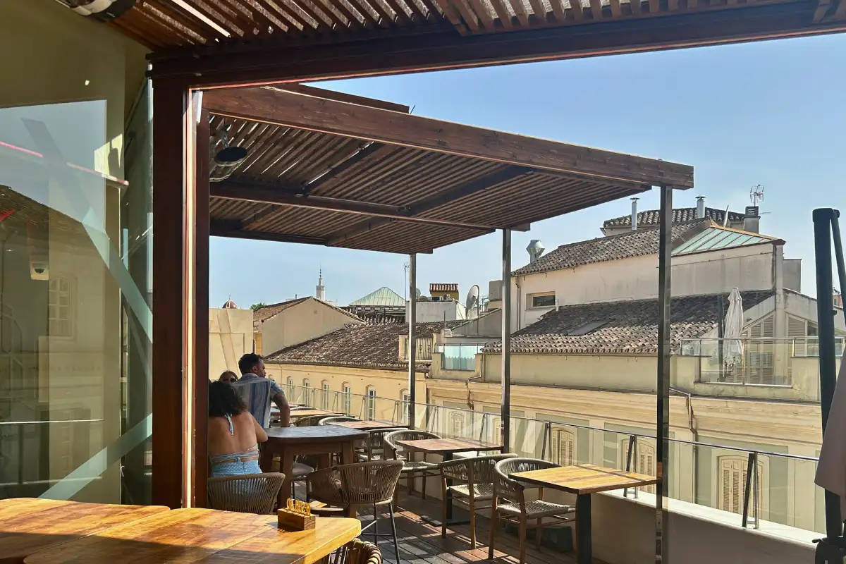 Covered wooden terrace with rooftop views over Malaga at Terraza Catedral bar
