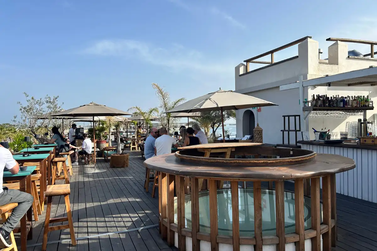 Decked rooftop terrace with parasols, bar counter and sea views at Trocadero Casa de Botes in Malaga