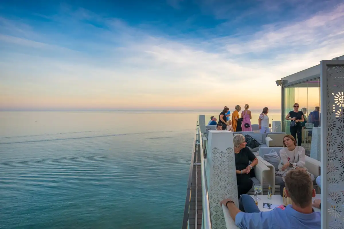 People at the terrace edge watching the sunset at The Belvue Marbella