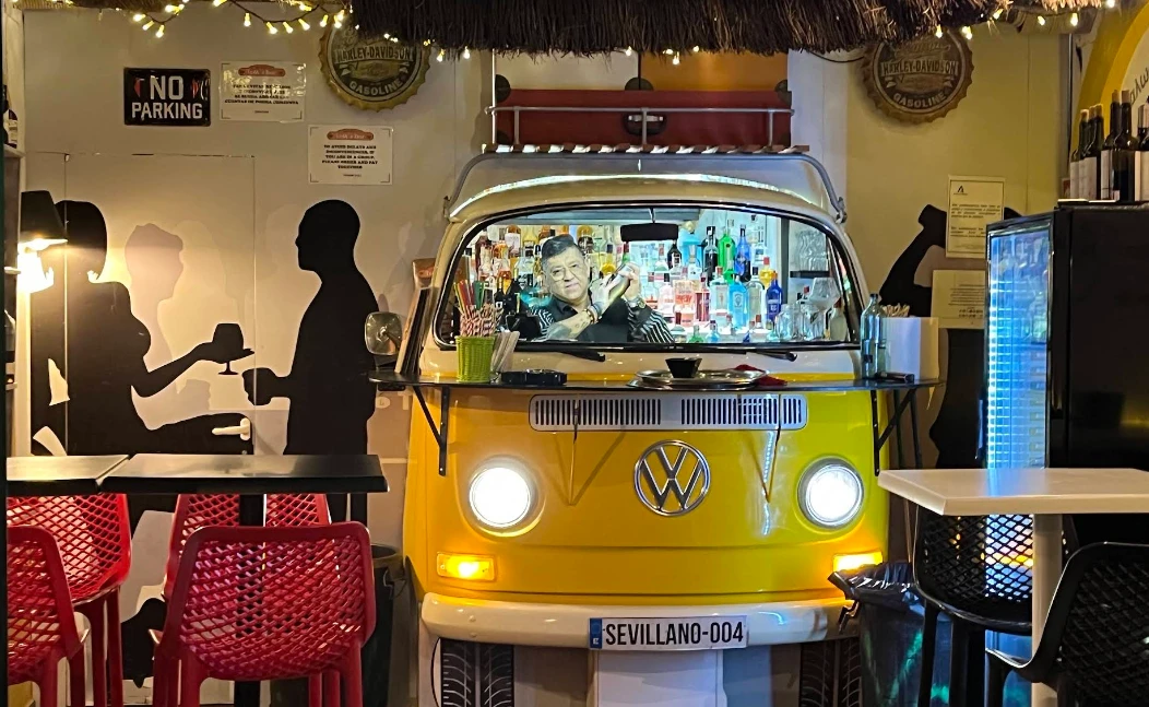 Yellow VW camper van converted into a cocktail bar on the rooftop at Volks Bar Nerja