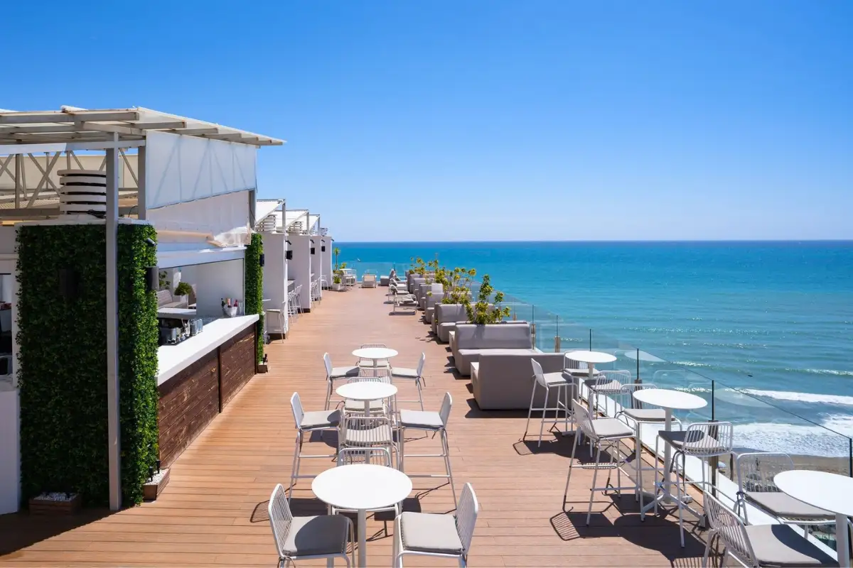 Long decked terrace with tables and sea view at Barracuda Torremolinos