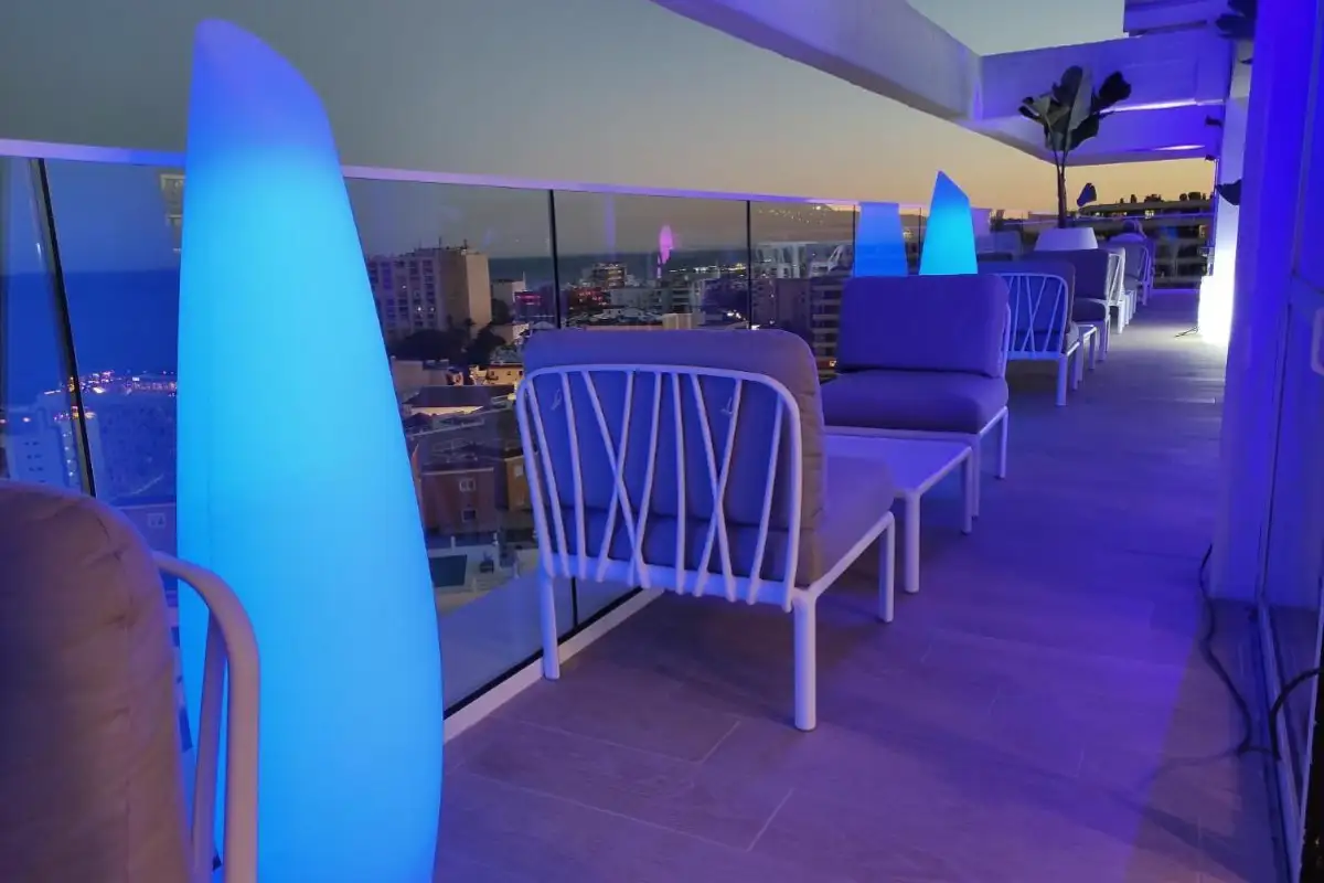 Blue-lit lounge seating at dusk on Blueside Skybar terrace in Torremolinos