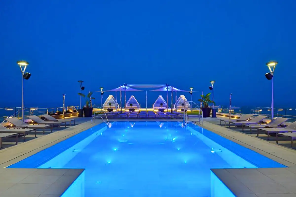 Blue-lit rooftop pool at night at Sky and Sea bar in Torremolinos