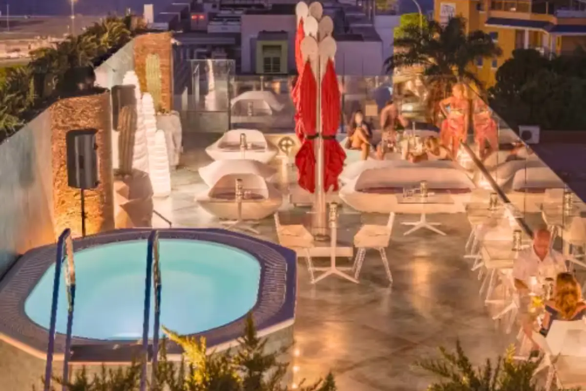 Evening jacuzzi and parasols lit up on Space Monkey rooftop in Torremolinos